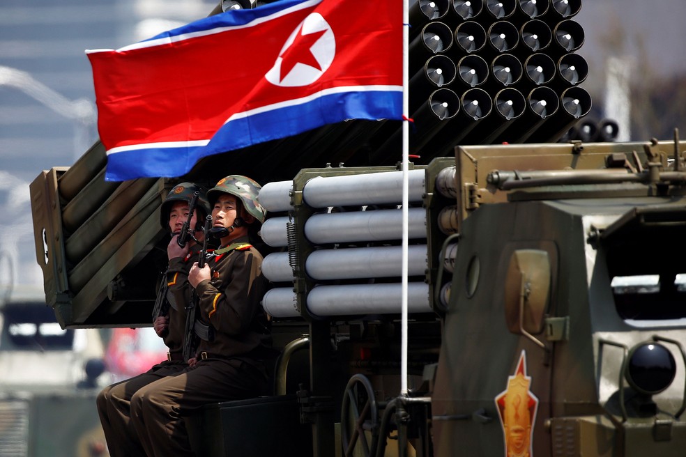 Soldados detêm armas sentados em um veículo carregando foguetes enquanto passam pelo estande com o líder norte-coreano Kim Jong Un durante desfile militar marcando o 105º aniversário de nascimento do pai fundador do país, Kim Il Sung, em Pyongyang, nesta sábado (15) (Foto: REUTERS/Damir Sagolj)