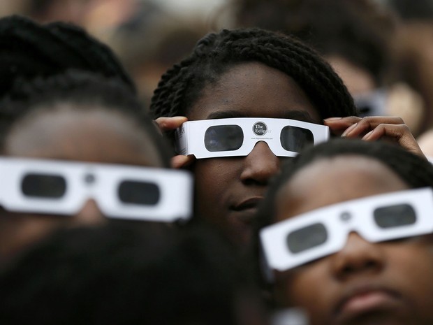 Crianças inglesas com óculos especiais tentam acompanhar o eclipse solar desta sexta-feira no Observatório Real de Greenwich, em Londres (Foto: Stefan Wermuth/Reuters)