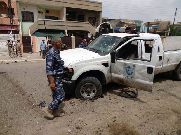 Soldados iraquianos inspecionam local de ataque suicida do lado de fora de centro de votação na cidade de Kirkuk nesta segunda-feira (28) (Foto: Marwan Ibrahim/AFP)