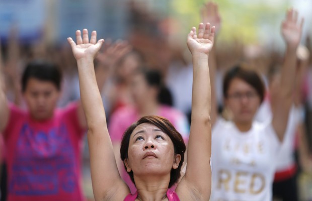Participante faz aula de ioga ao livre em Kuala Lumpur, na Malásia (Foto: Samsul Said/ Reuters)