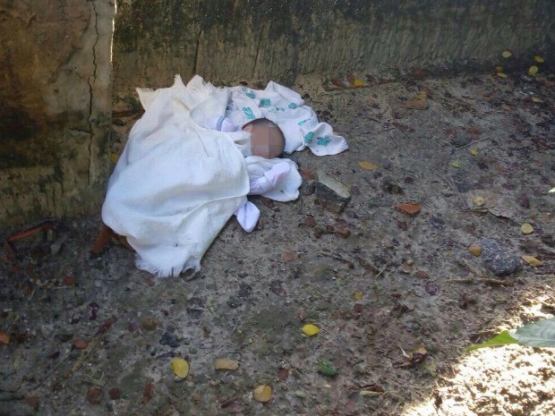 Bebê foi encontrado em terreno baldio após moradores se guiarem por latidos de cão (Foto: Polícia Militar/Divulgação)