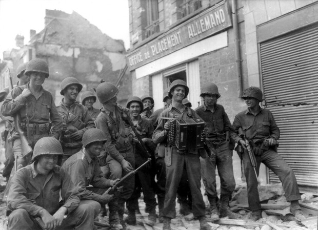 Soldados se divertem próximo de ruínas do escritório alemão na rua Saint Germain [Foto: Conseil Régional de Basse-Normandie/National Archives USA/PhotosNormandie)