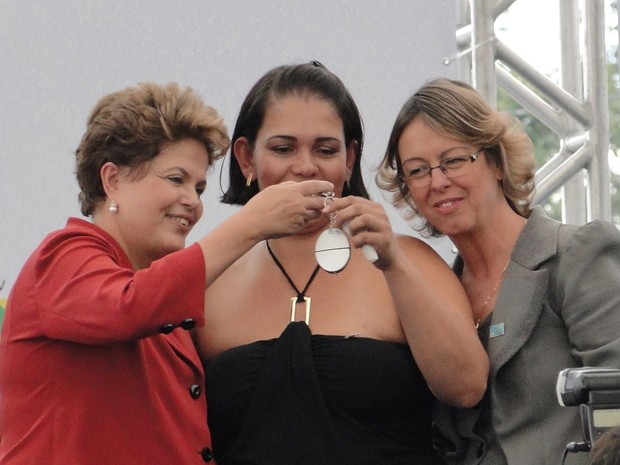 Moradadora recebe das mãos da presidente chave de apartamento do 'Minha Casa, Minha Vida'; à direita, prefeita de Betim, Maria do Carmo Lara. (Foto: Pedro Triginelli/G1)