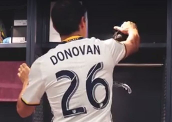 Landon Donovan vestido com a camisa 26 do Los Angeles Galaxy pega as chuteiras no armário do vestiário (Foto: Reprodução de vídeo)