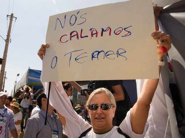 Manifestante mostra cartaz após o vice-presidente da República Michel Temer cancelar discurso na Agrishow (Foto: Érico Andrade/G1)