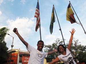 Renê Silva e Daiene Mendes em frente às banderas dos Estados Unidos e do Brasil, na Praça das Nações, em Bonsucesso (Foto: Carolina Lauriano/G1)