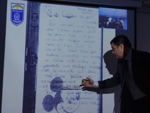 Delegado Paulo Berenguer projetou páginas do diário escrito pelo suspeito (Foto: Katherine Coutinho/G1)