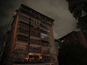 Um homem espera, na varanda de seu apartamento em Caracas, a volta da energia elétrica. (Foto: Carlos Garcia Rawlins / Reuters)