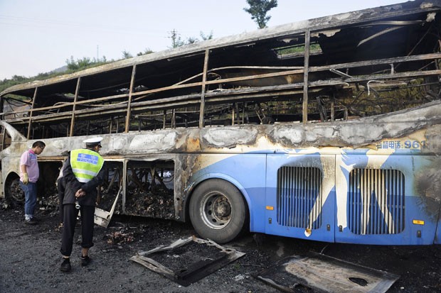 Polícia inspeciona ônibus envolvido no acidente. (Foto: Li Yibo/Xinhua/AP)