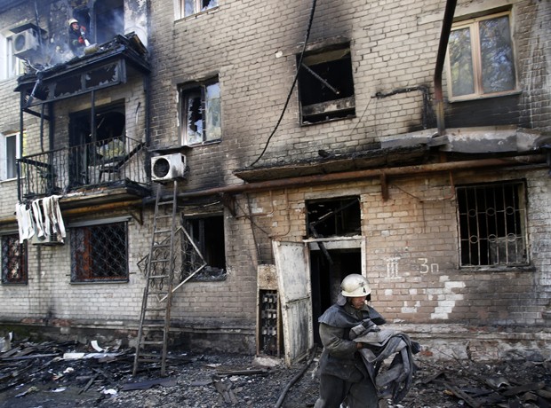 Bombeiros trabalham em edifício incendiado após bombardeio na cidade de Donetsk, leste da Ucrânia (Foto: Darko Vojinovic/AP)