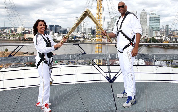 Nadia Comaneci e John Amaechi com a tocha olímpica na Greenwich Arena Londres (Foto: AP)
