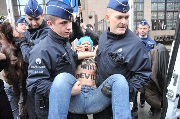 Seminuas, ativistas protestam contra presidente russo em Bruxelas nesta sexta-feira (21) (Foto: AFP)