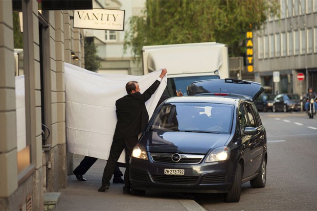 Dirigentes da Fifa são levados de um hotel em Zurique após sua detenção, e são encobertos por lençóis (Foto: Pascal Mora/The New York Times)