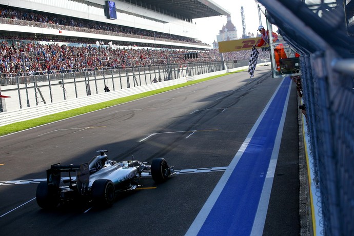 Diante de arquibancadas lotadas, Lewis Hamilton recebe a bandeirada para a vitória do primeiro GP da Rússia (Foto: Getty Images)