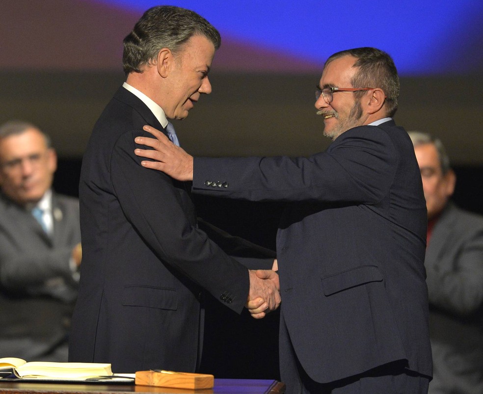 Presidente da Colômbia, Juan Manuel Santos, e líder das Farc, Rodrigo Londoño, durante assinatura de acordo (Foto: LUIS ROBAYO/AFP)
