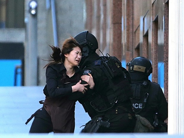 Refém corre em direção ao policial após deixar café na Austrália (Foto: AP Photo/Rob Griffith) Refém corre em direção ao policial após deixar café na Austrália (Foto: AP Photo/Rob Griffith)