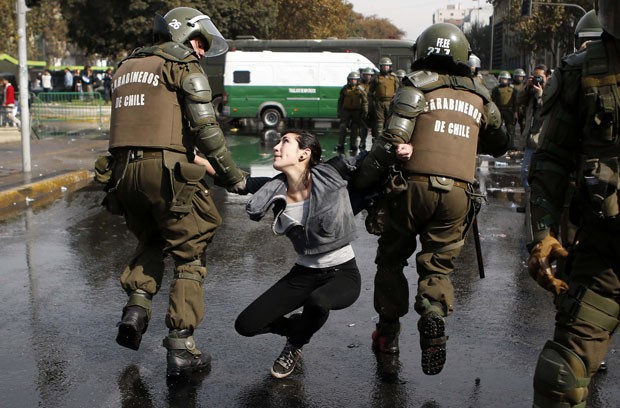 Menina é presa durante confronto com polícia em Santiago (Foto: Ivan Alvarado/Reuters)