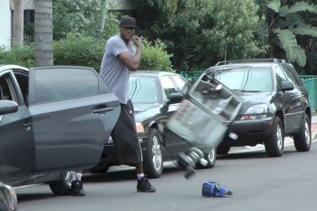 Lamar Odom joga mala com material de fotógrafo para fora do carro (Foto: Splash News)