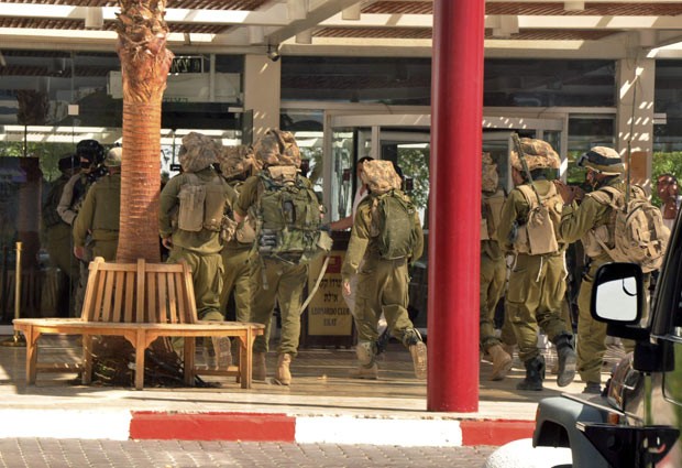 Soldados israelenses entram no hotel em que ocorreu o tiroteio desta sexta-feira (5) em Eilat (Foto: AP)