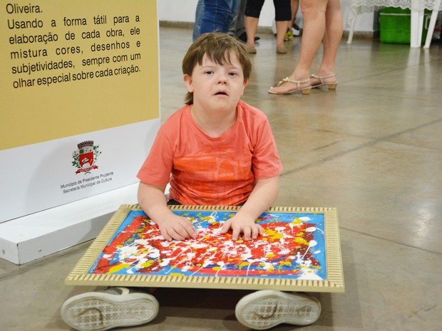 Matheus Fernandes Raimundo, de 9 anos, faz pinturas com as mãos (Foto: Olímpio Moura/Divulgação)