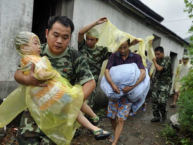 Socorristas ajudar a retirar moradores de suas casas em Zhoushan, na província de Zhejiang, leste do país. (Foto: AFP Photo)
