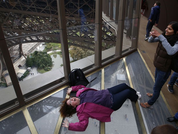 Mulher deita para foto no novo piso transparente da Torre Eiffel (Foto: Francois Mori/AP)