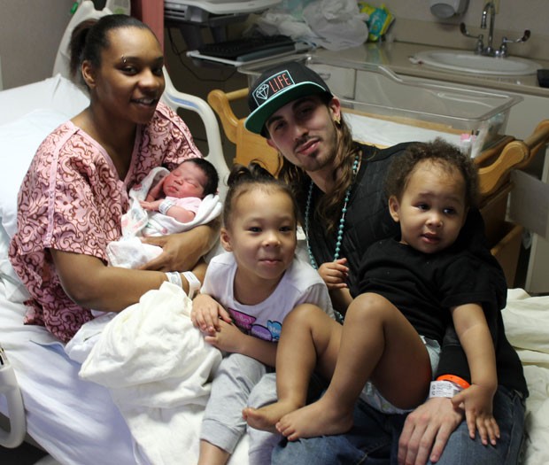 Shaniqua Cherry é vista no hospital com seu bebê recém-nascido, seu namorado, Hassan Lulu, e dois de seus filhos, Malaysha e Lamarion (Foto: Skip Foreman/AP)