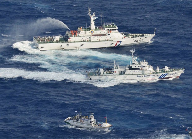 Foto aérea mostra navio de patrulha da Guarda Costeira de Taiwan (acima), outro da Guarda Costeira do Japão (ao centro) e barco de pesca de Taiwan, nesta terça-feira (25), próximo às ilhas Senkaku/Doaoyu (Foto: AFP)