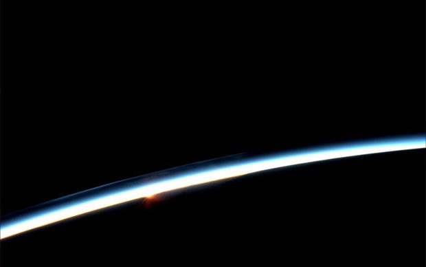 Sol nasce atrás da Terra (Foto: Karen Nyberg/Nasa/AFP)