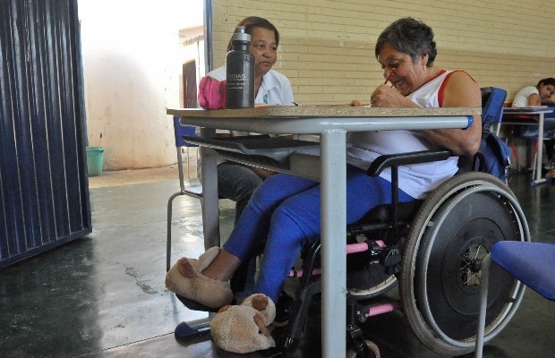 Maria é cadeirante e, aos 63 anos, realiza seu sonho de aprender a ler e escrever, em Goiás (Foto: Vitor Santana/G1)