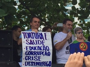 Durante a manifestação, o deputado exibia um cartaz com a seguinte frase: &quot;Tortura é saúde, educação, corrupção, crise e desemprego&quot;. (Foto: Alba Valéria Mendonça/G1)