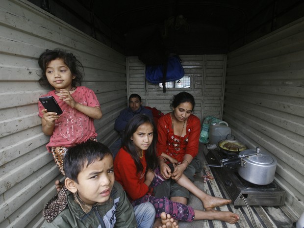 Com medo de novos tremores, famlia passam a viver dentro de carros e caminhes (Foto: Bikram Rai / AP)