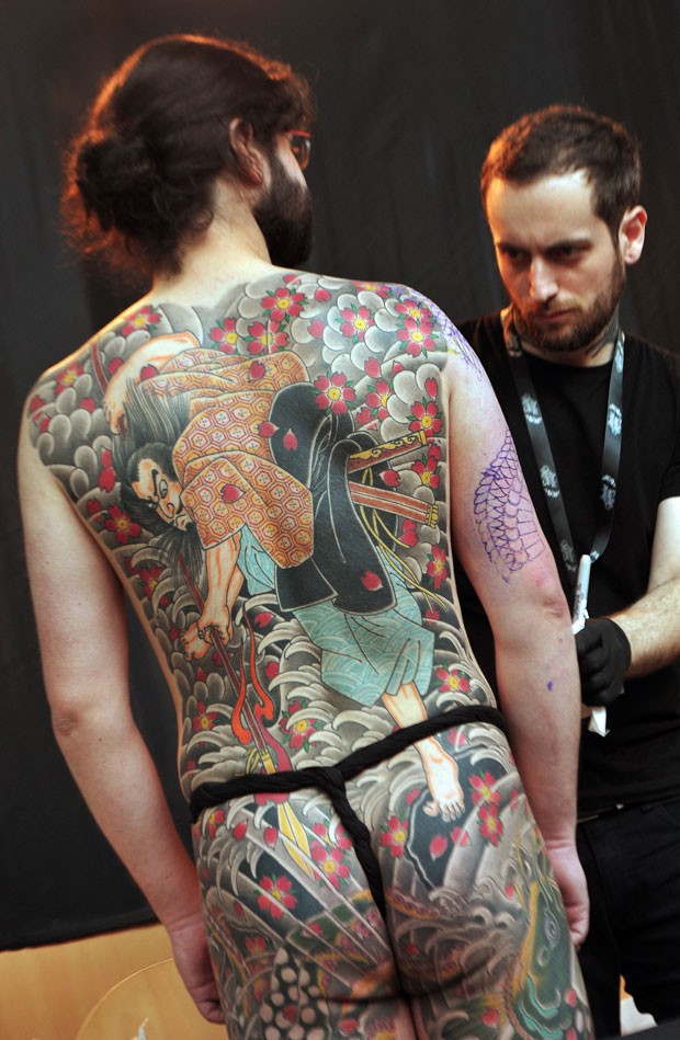 Participante exibe o corpo tatuado durante a feira (Foto: Pierre Andrieu/AFP)
