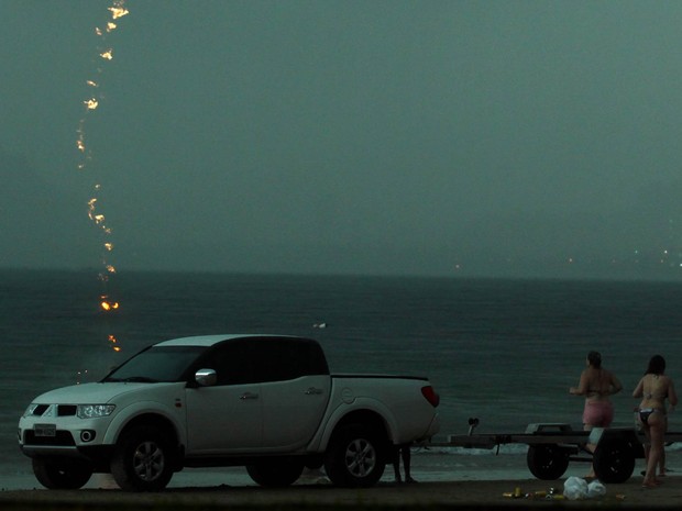 Rastro do raio é visto cortando o céu, no momento em que a banhista, que estava atrás do veículo na areia, foi atingida. (Foto: Rogério Soares/Jornal A Tribuna)