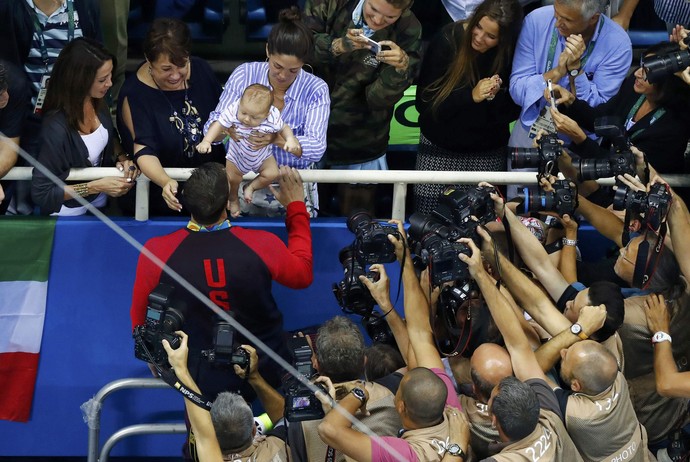 Phelps vai até esposa, mãe e filho após receber medalha (Foto: Reuters)
