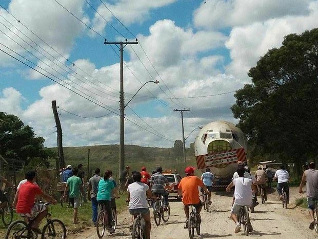 Moradores seguem o avião de bicicleta nas ruas de Dom Pedrito, RS (Foto: Giana Cunha/RBS TV)