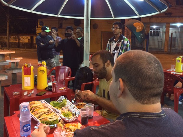 Frequentadores da lanchonete pararam para observar e registrar a dupla comendo o super sanduíche (Foto: Daniel Silveira / G1)