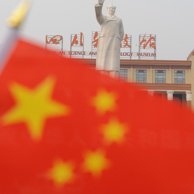 Estátua do antigo líder chinês Mao Tsé-tung é vista atrás da bandeira nacional da China em Chengdu, na China ; economia da China (Foto: China Photos/Getty Images)
