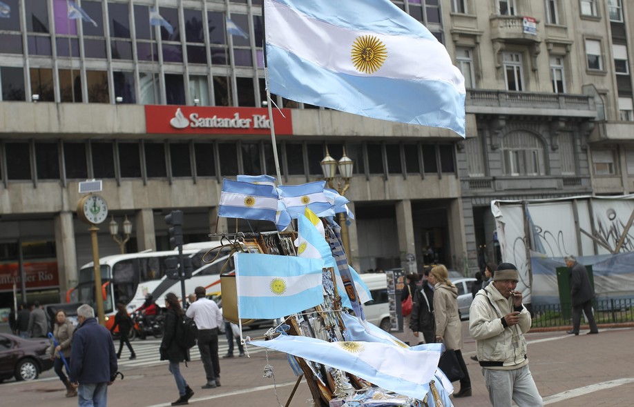 Homem vende bandeiras da Argentina no centro de Buenos Aires. País deu novo calote na dívida externa
