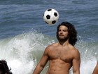 Com os cabelos compridos, Duda Nagle joga futebol na praia