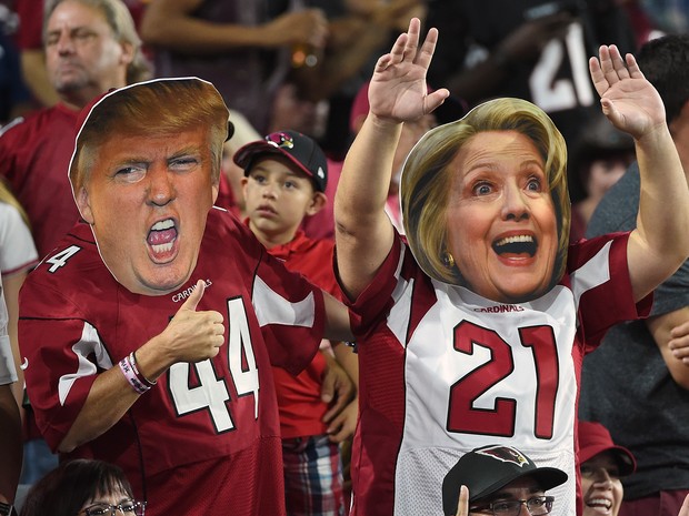 Torcedores do time de futebol americano Arizona Cardinals usam máscaras dos candidatos americanos Donald Trump e Hillary Clinton em jogo nesta segunda-feira (17) (Foto: Norm Hall/Getty Images/AFP )