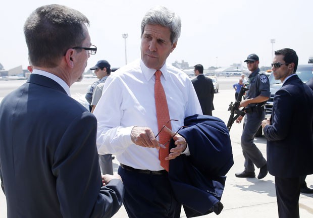 O secretário americano de Estado, John Kerry, é recebido por Bill Grant, vice-chefe de missão da embaixada dos EUA em Israel, ao chegar ao país nesta quarta-feira (23) (Foto: AFP)