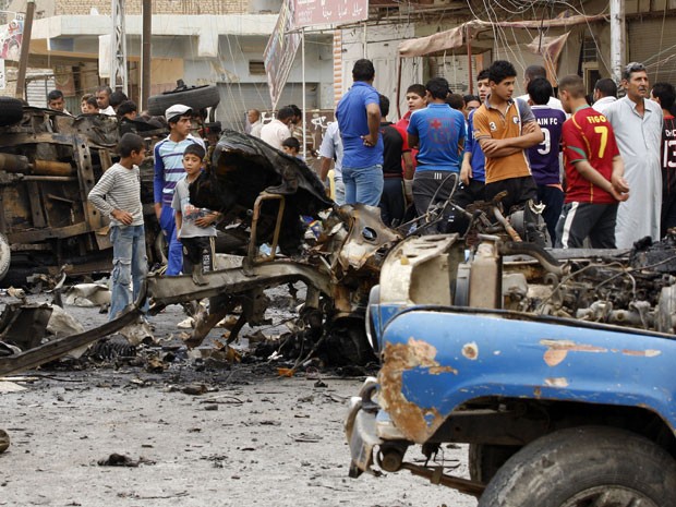 Civis observam carro-bomba que explodiu em bairro xiita de Kamaliyah nesta segunda (20) (Foto: Reuters)