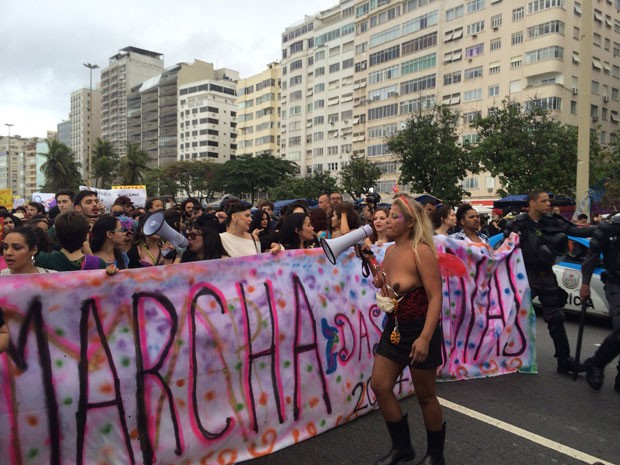 Ativista segue à frente da passeata de topless e megafone (Foto: Lívia Torres / G1)