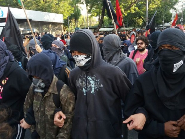 Mascarados participam de protesto contra a olimpíada na Praça Saens Peña (Foto: G1)