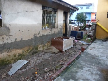 Os muros que dividem o terreno onde Márcia mora com as residências vizinhas caíram (Foto: Thais Kaniak / G1 PR)