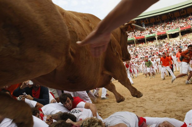 Animal salta barreira de contenção em Pamplona, na Espanha, na primeira corrida de touros do Festival de São Firmino, neste sábado (7) (Foto: Joseba Etxaburu / Reuters)