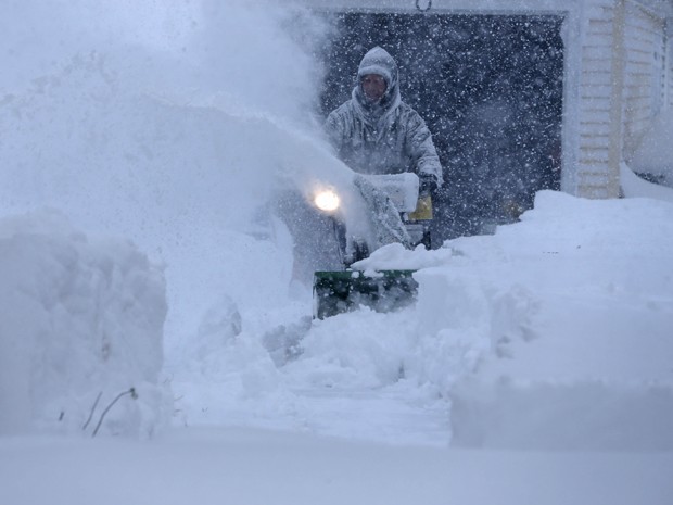 Jerry Delzer tenta retirar a neve da entrada de sua garage em Depew, NY, na terça-feira (18) (Foto: AP Photo/The Buffalo News, Derek Gee)