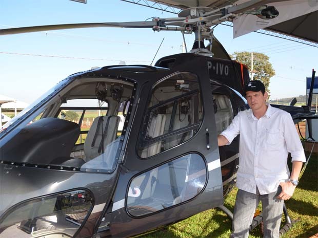 Piloto em frente a modelo de helicóptero comprado pelo patrão em feira agrícola de Ribeirão, SP (Foto: Leandro Mata/G1)