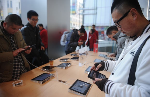 Consumidores olham o novo iPad mini em uma loja da Apple em Xangai nesta sexta-feira (7). (Foto: Peter Parks/AFP)